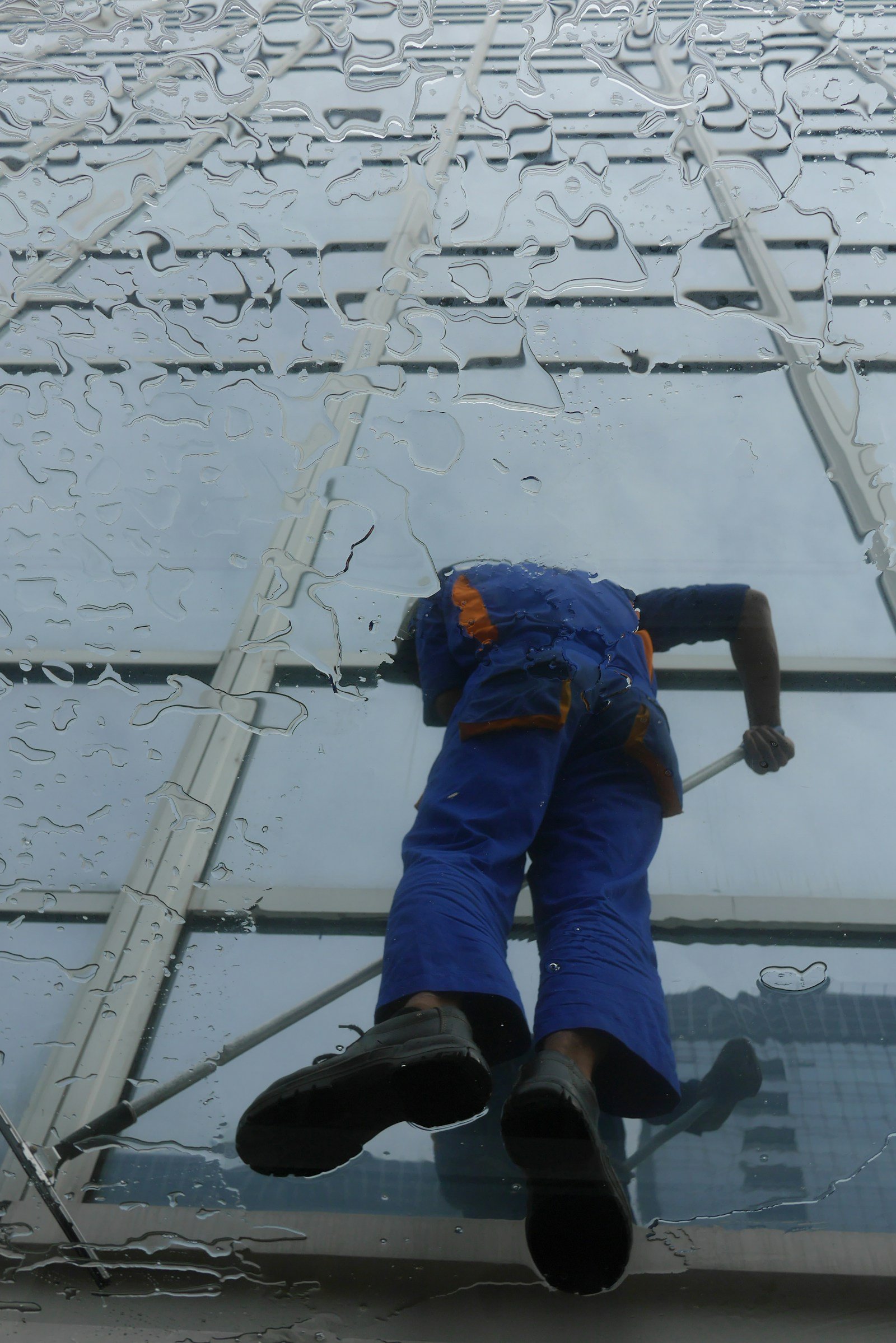 Professional cleaner working on a commercial glass building